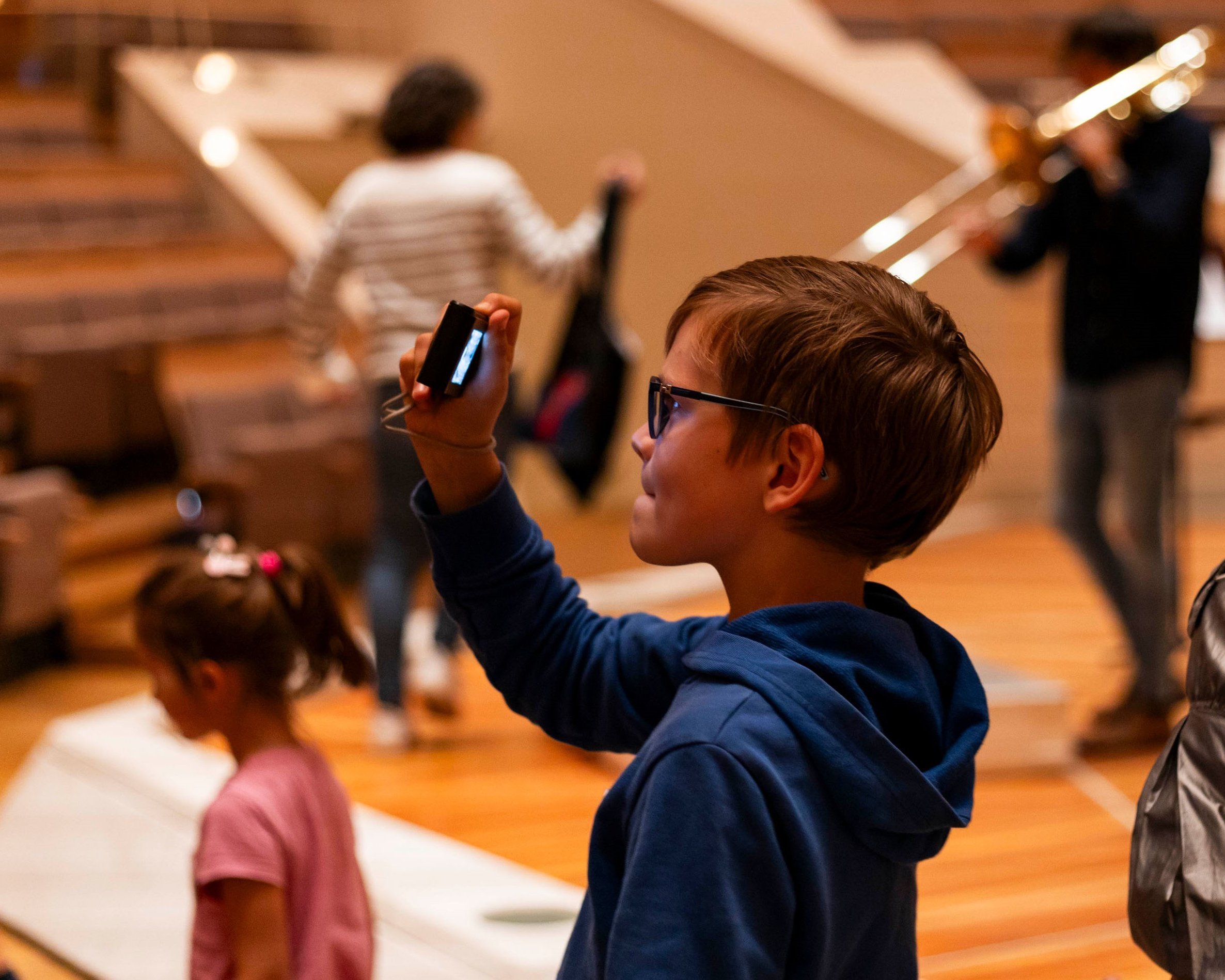 Junge macht mit seinem Handy ein Foto in der Philharmonie.