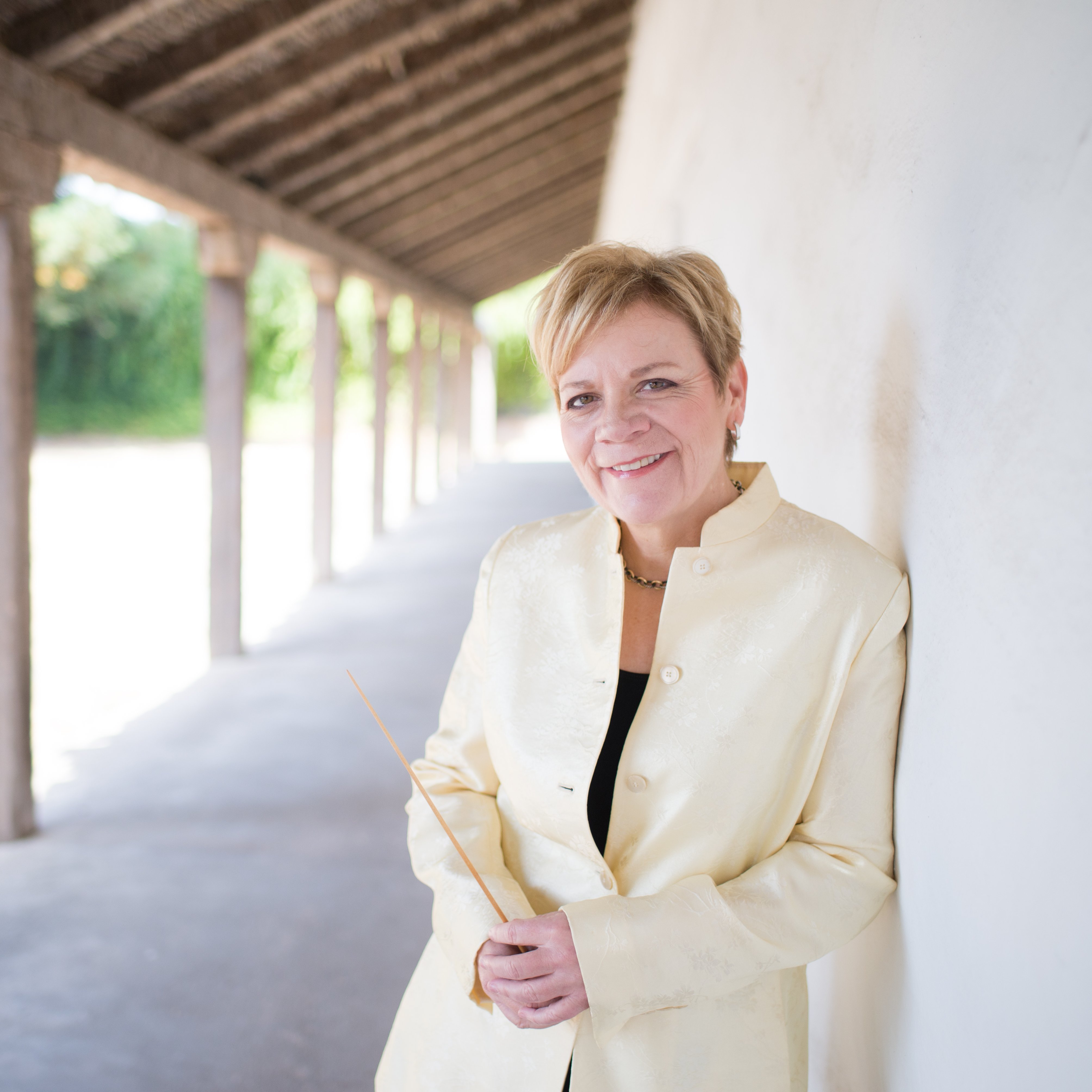 Marin Alsop lehnt an einer Mauer