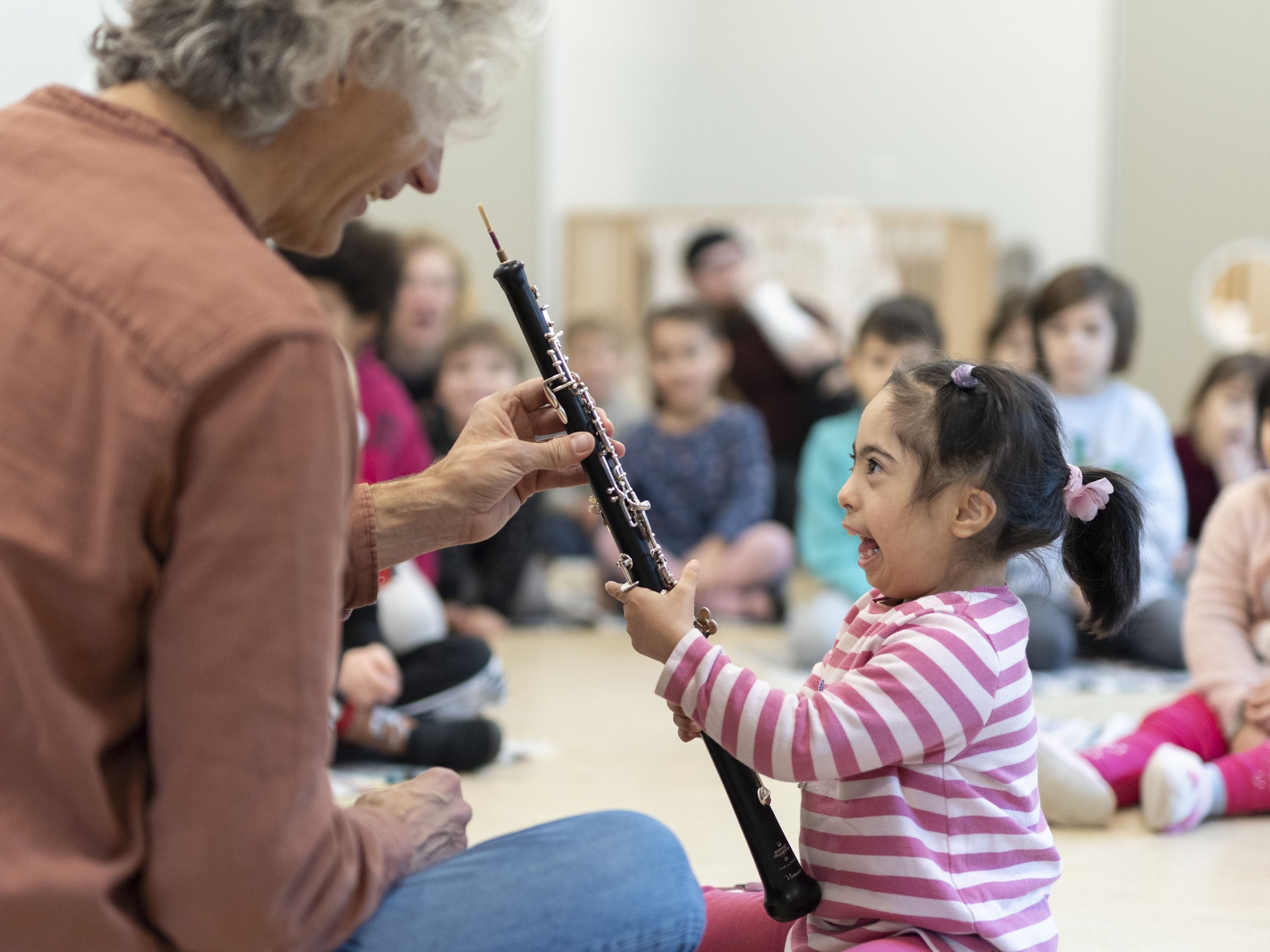 Musiker zeigt kleinem Kind eine Oboe