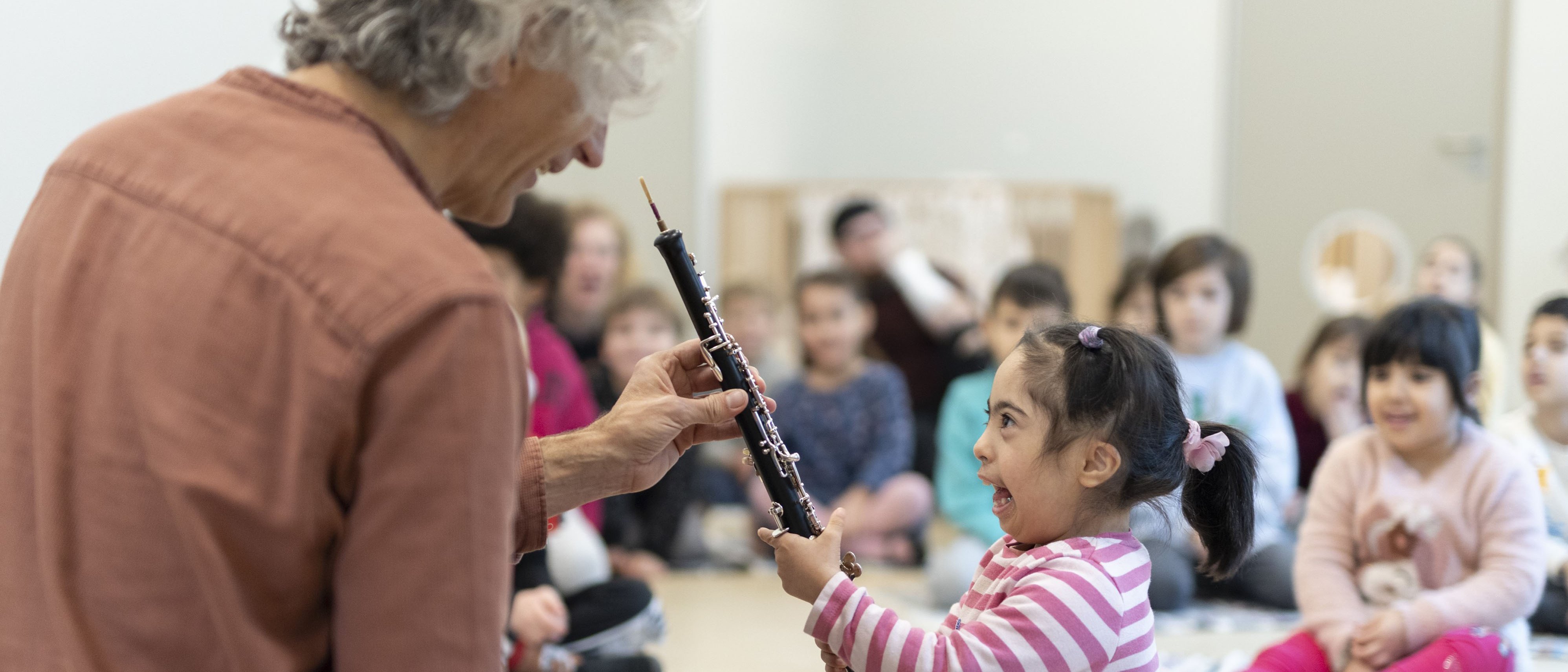 Musiker zeigt kleinem Kind eine Oboe