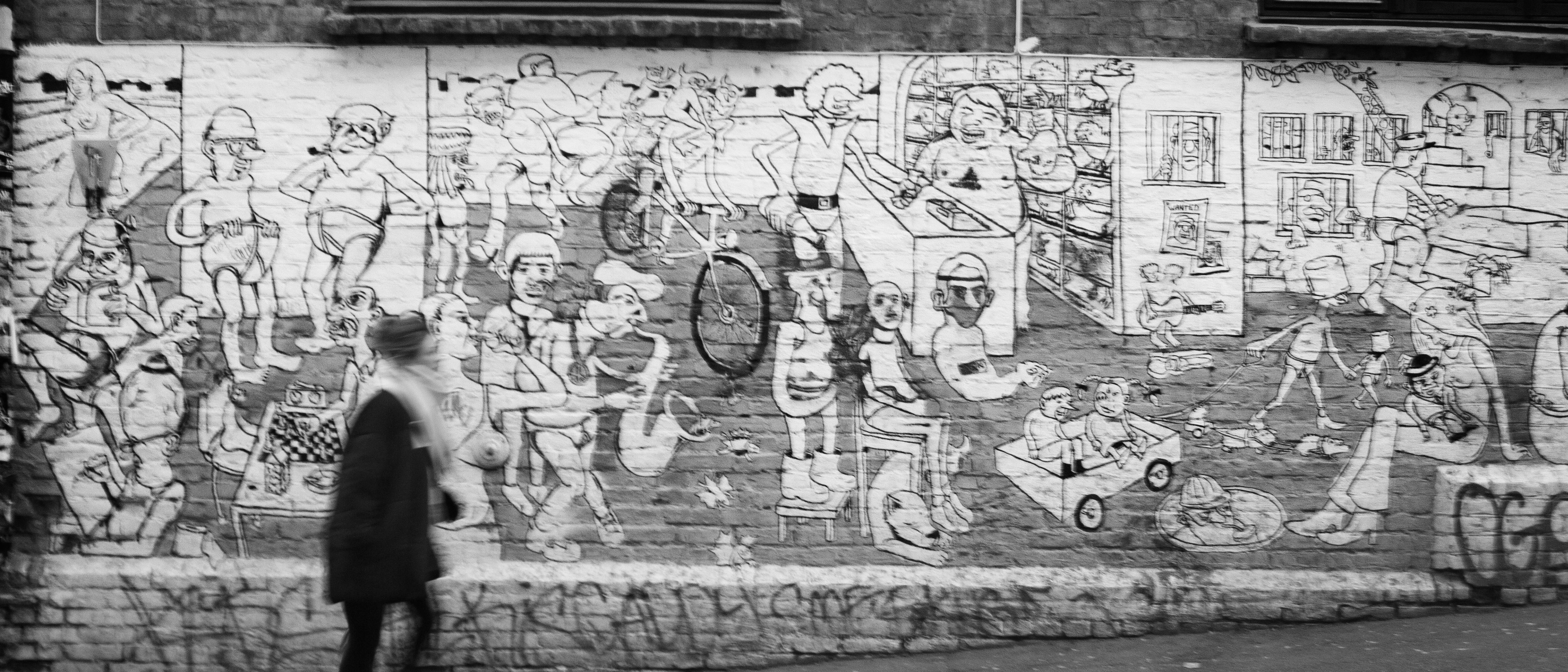 Frau vor einer Backsteinwand mit gezeichneten Graffiti