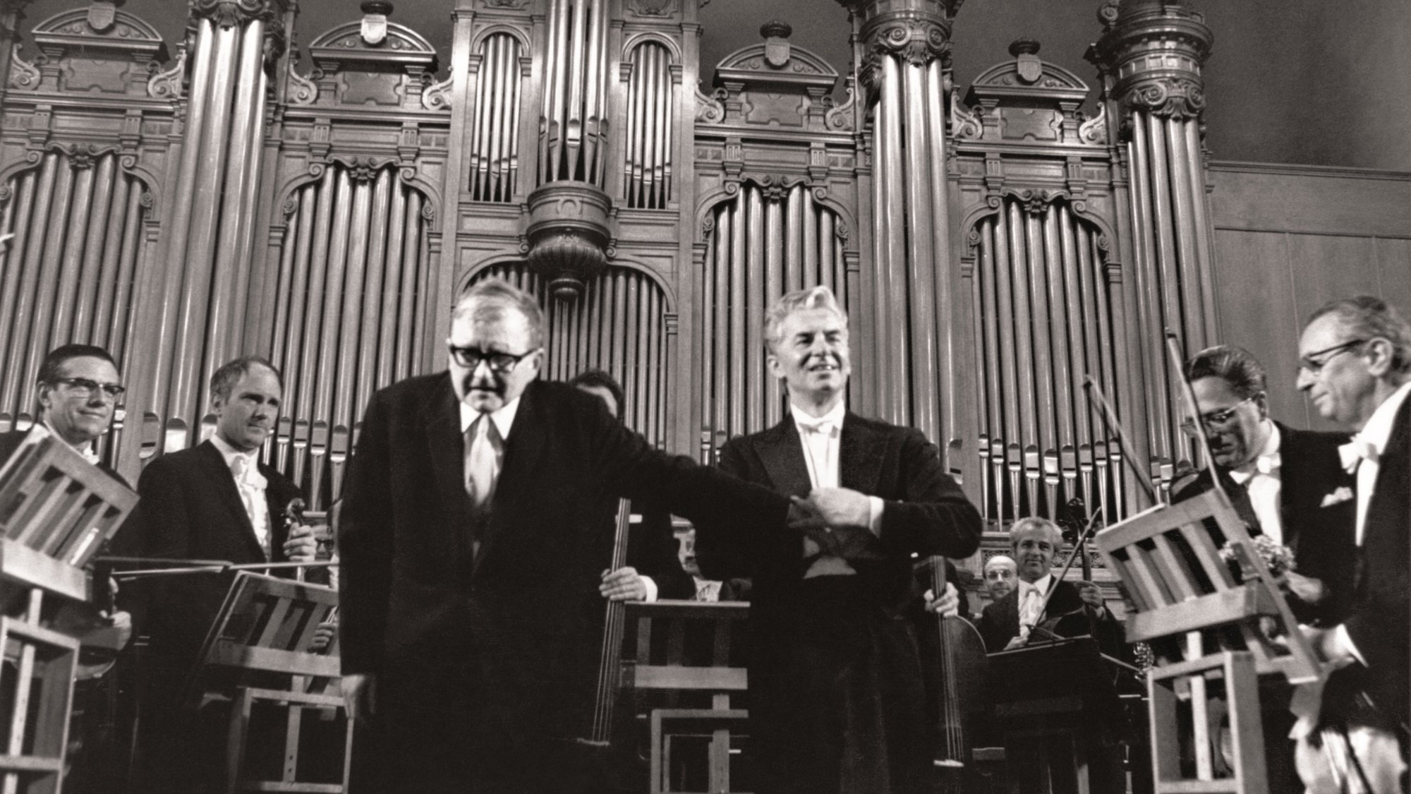 Schostakowitsch (links) und Karajan (rechts) vor dem Orchester, sich verbeugend.