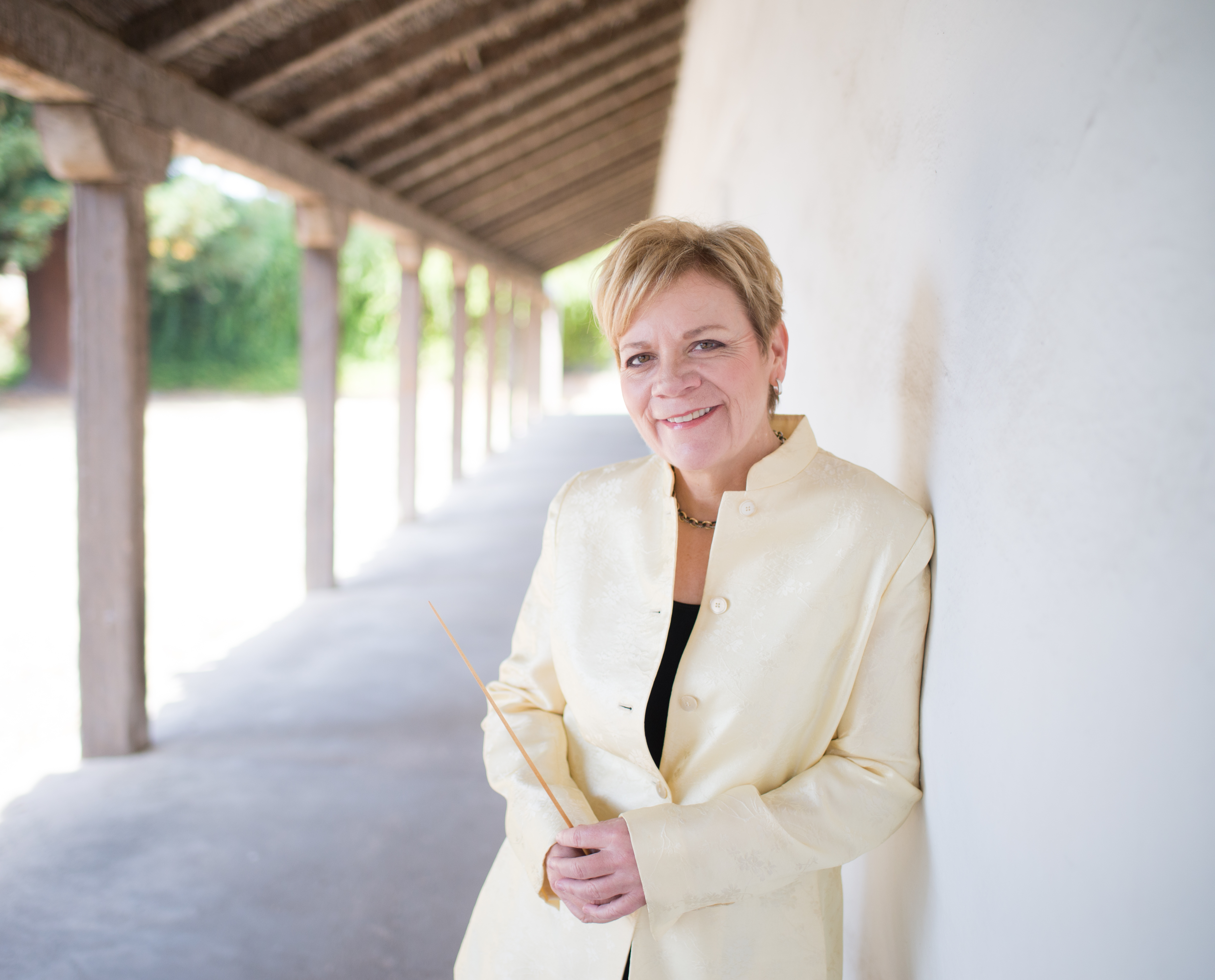 Marin Alsop lehnt an einer Mauer